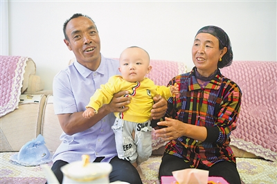 <p>　　劉克瑞（左）和妻子在客廳中陪孫子玩耍?！【緢笥浾摺●R楠　攝</p>
