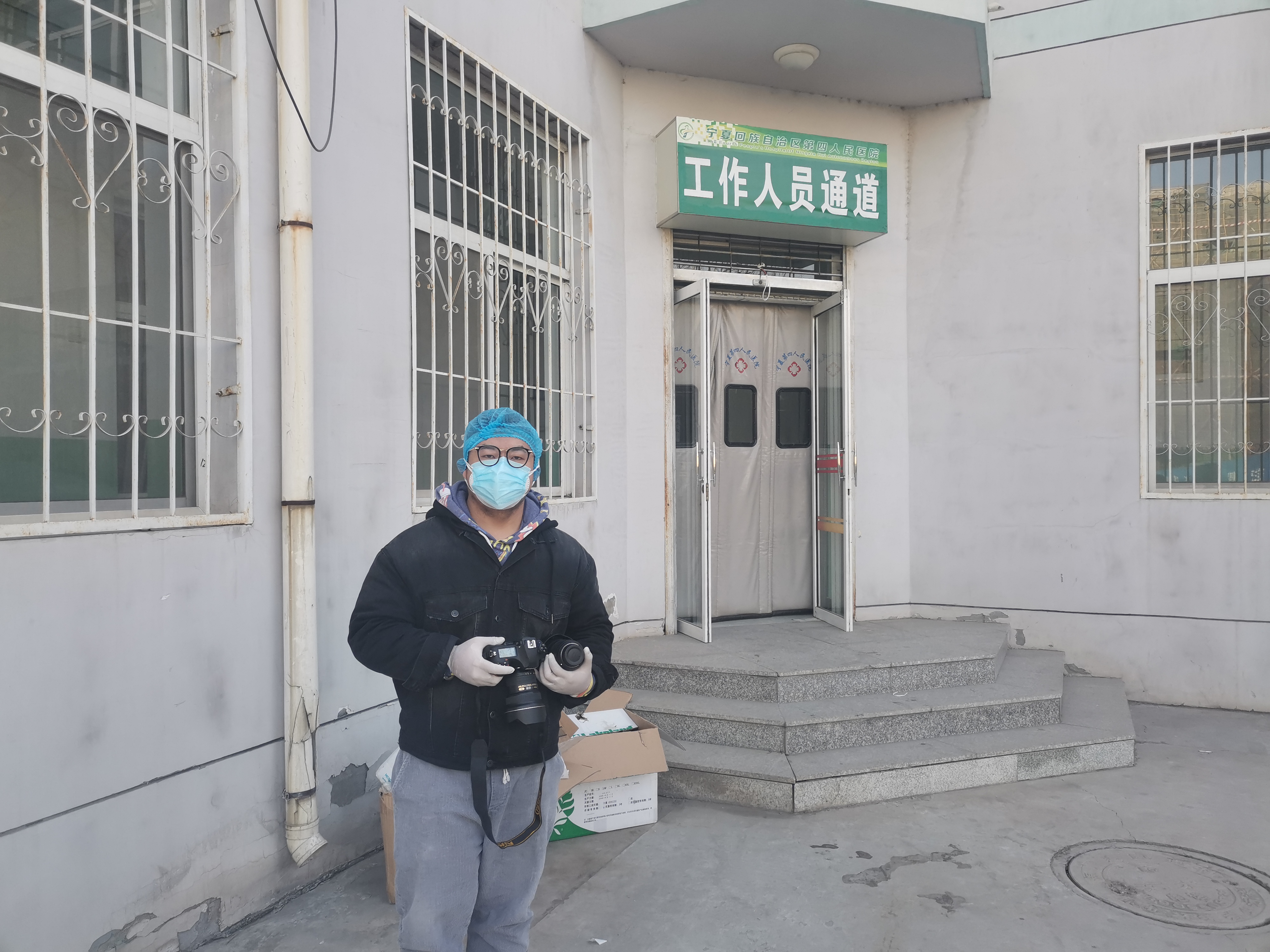 1月27日，寧報集團馬楠在自治區第四人民醫院隔離病區樓門前全副武裝，準備從工作人員通道進入該樓的清潔區采訪。.jpg